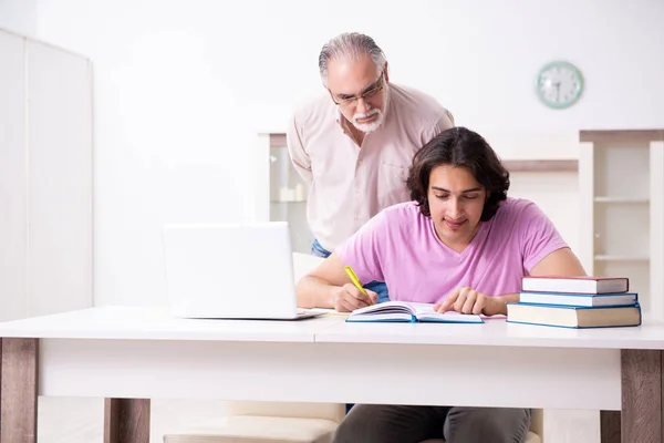 Gammal far hjälper sin son i examen förberedelse — Stockfoto