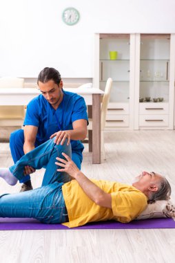 Genç erkek doktor eski hastayı ziyaret ediyor.