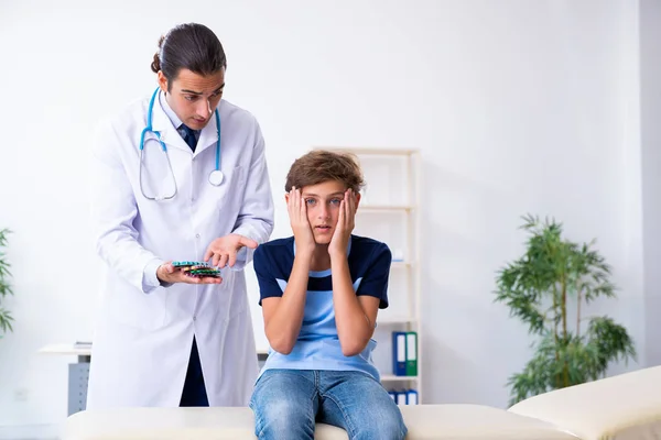 젊은 남성 의사가 진료소에서 소년을 진찰하고 있다 — 스톡 사진