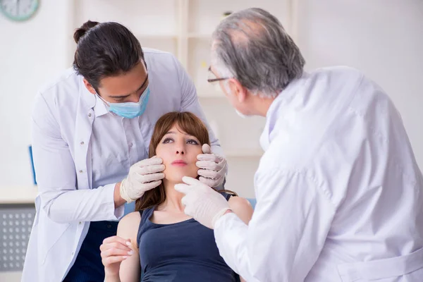 Deux médecins masculins et une jeune femme en chirurgie plastique concept — Photo