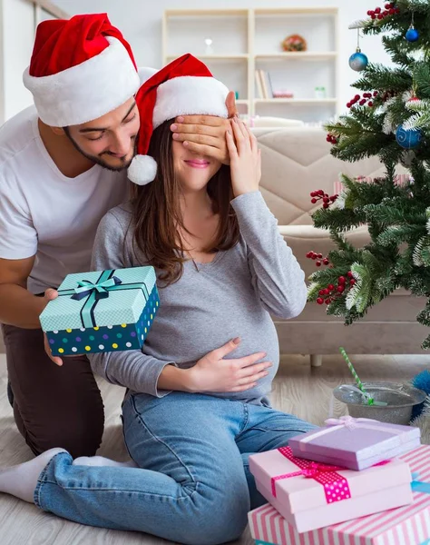 Mladá rodina očekává dítě oslavující Vánoce — Stock fotografie