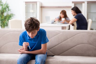 Genç bir çocuk ve ailesiyle sigara içme kavramı