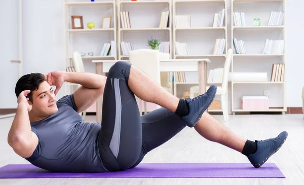 Young man exercising at home in sports and healthy lifestyle con — Stock Photo, Image