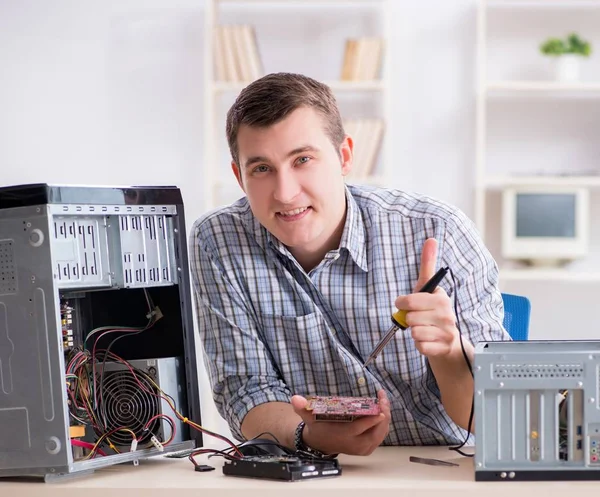 Young technician repairing computer in workshop — Stock Photo, Image