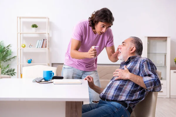 Giovane studente e il suo vecchio nonno a casa — Foto Stock