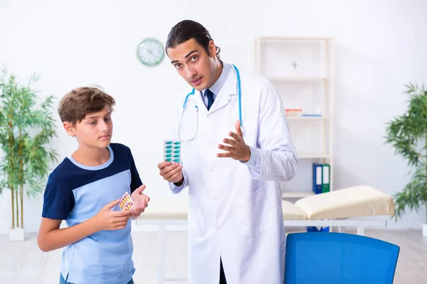 Jovem médico examinando menino na clínica — Fotografia de Stock