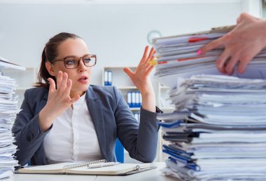 Evrak işleriyle uğraşan yorgun bir iş kadını.