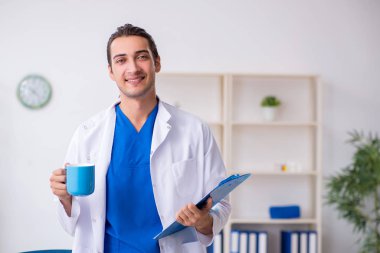 Klinikte çalışan genç erkek doktor.