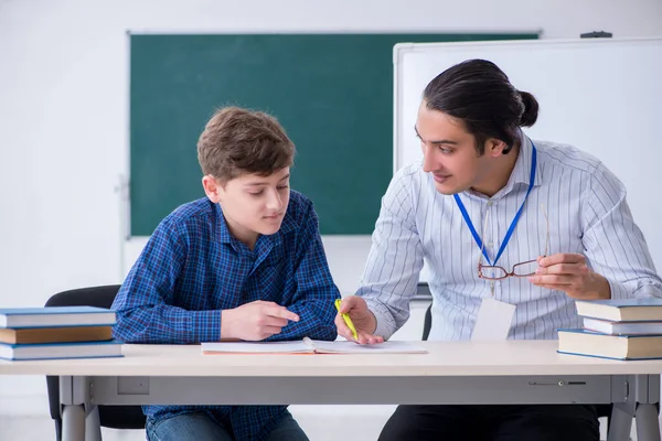 Jeune enseignant et garçon dans la salle de classe — Photo