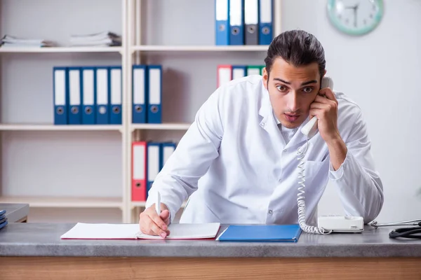 Hastanedeki resepsiyondaki genç erkek doktor. — Stok fotoğraf