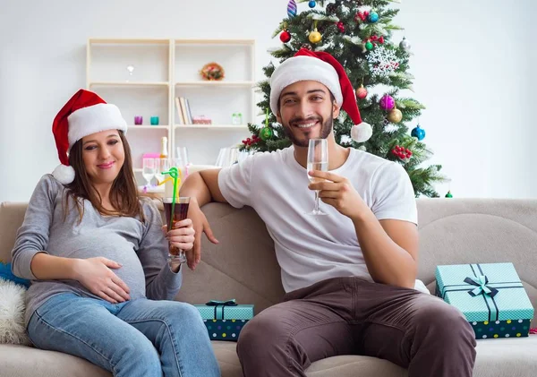 Jeune famille attend bébé célébrant Noël — Photo