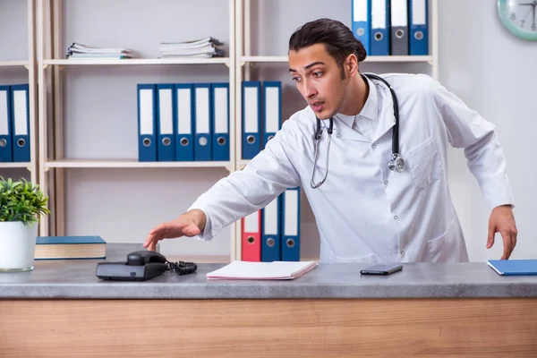 Hastanedeki resepsiyondaki genç erkek doktor. — Stok fotoğraf