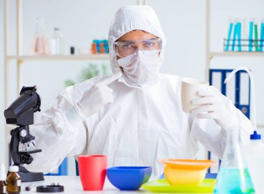 Plastik tabakları kontrol edip test eden kimyager.