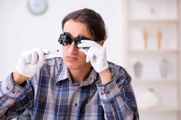 Jonge mannelijke juwelier in werkplaats — Stockfoto