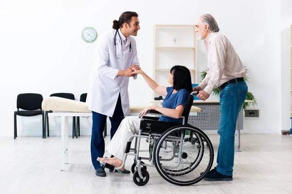 Yaşlı çift genç erkek doktoru ziyaret ediyor.