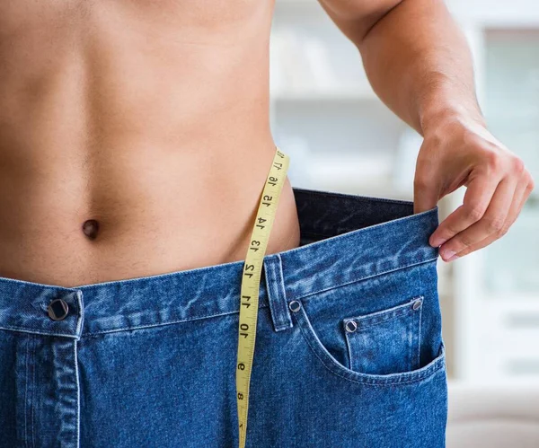 Hombre en pantalones de gran tamaño en concepto de pérdida de peso — Foto de Stock