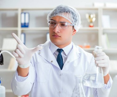 Genç araştırmacı bilim adamı bir su testi kirliliği araştırması yapıyor.