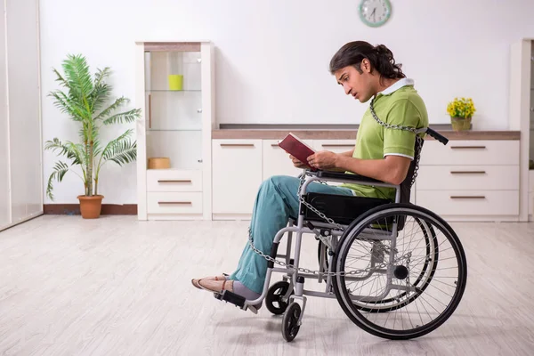 Jeune homme invalide en fauteuil roulant souffrant à la maison — Photo