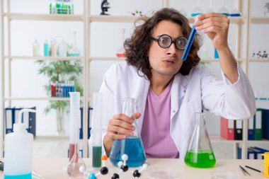 Laboratuvarda çalışan komik erkek kimyager.