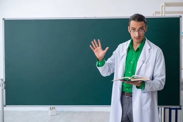 Joven profesor químico frente a pizarra — Foto de Stock