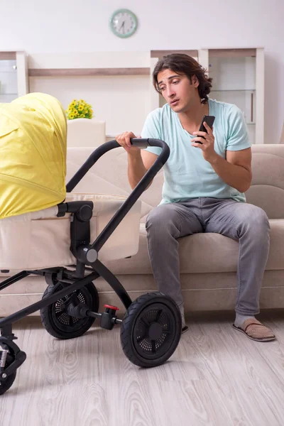 Jovem cuidando do bebê no carrinho — Fotografia de Stock