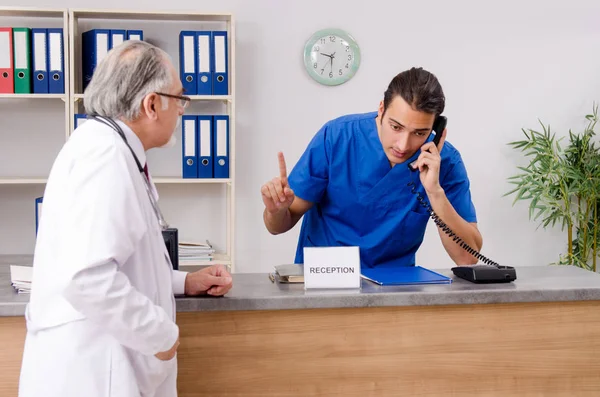 Hastanedeki resepsiyonda iki doktor konuşuyor. — Stok fotoğraf