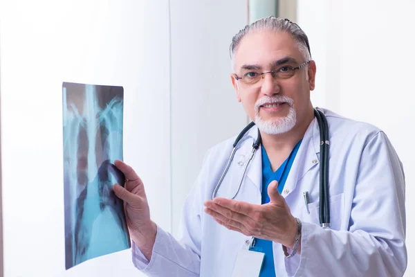 Gammal manlig läkare som arbetar på kliniken — Stockfoto