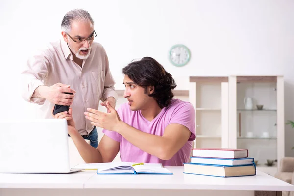Oude vader helpt zijn zoon bij de voorbereiding van het examen — Stockfoto