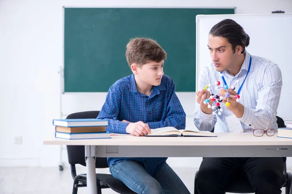 Jonge mannelijke leraar uitleggen moleculair model — Stockfoto