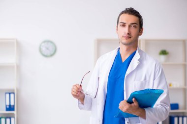 Klinikte çalışan genç erkek doktor.