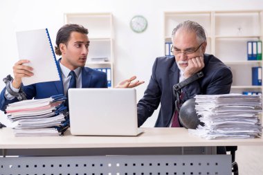 İki erkek çalışan aşırı işten memnun değil.