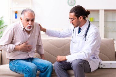 Genç erkek doktor eski hastayı ziyaret ediyor.