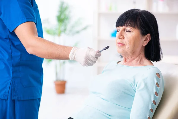 Alte Frau besucht männlichen Arzt für plastische Chirurgie — Stockfoto