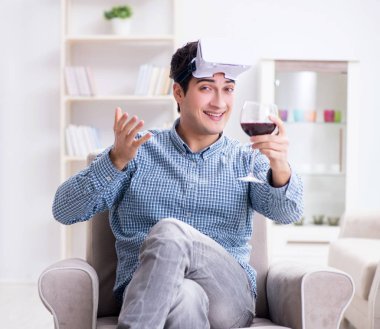 Genç adam evde şarap içiyor.
