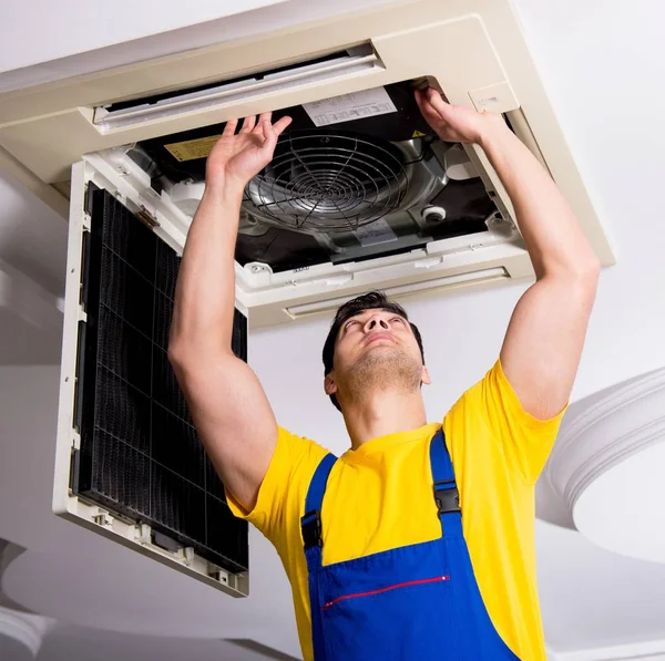 Reparador reparando unidade de ar condicionado teto — Fotografia de Stock