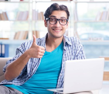 Bilgisayarlı beyaz öğrenci üniversite sınavlarına hazırlanıyor.