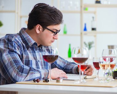 Profesyonel şarap garsonu kırmızı şarap tadıyor.