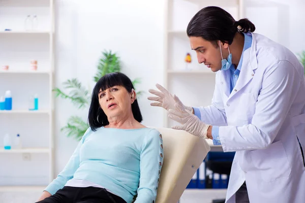 Velha mulher visitando jovem médico laringologista — Fotografia de Stock