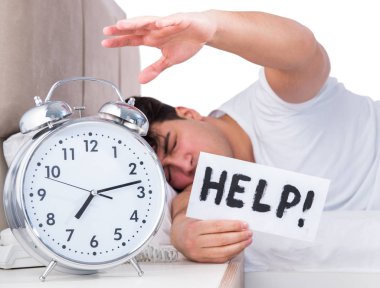 Yatakta uykusuzluk çeken bir adam.