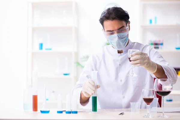 Mužský chemik vyšetřuje vzorky vína v laboratoři — Stock fotografie