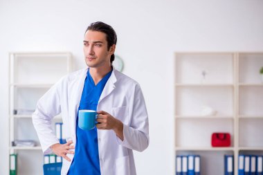 Klinikte çalışan genç erkek doktor.