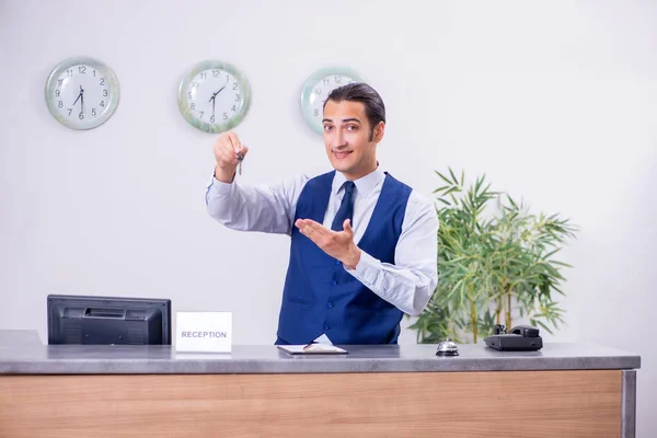 Young man receptionist at the hotel counter — Stock Photo, Image