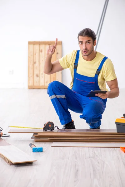 Jovem empreiteiro do sexo masculino trabalhando dentro de casa — Fotografia de Stock