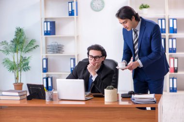 Patron ve erkek asistanı ofiste çalışıyor.