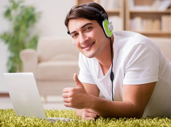 Giovane uomo che ascolta la musica dal computer portatile — Foto Stock