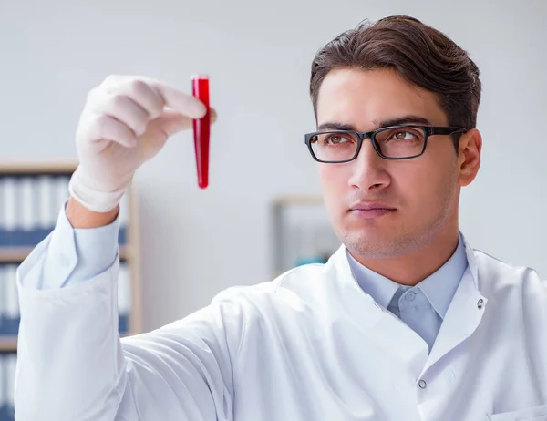 Junge Ärztin im Labor mit roter Röhre — Stockfoto