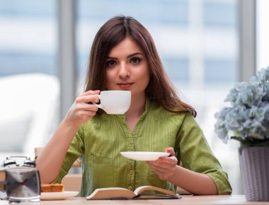 Sınavlara hazırlanan genç öğrenci çay içiyor.