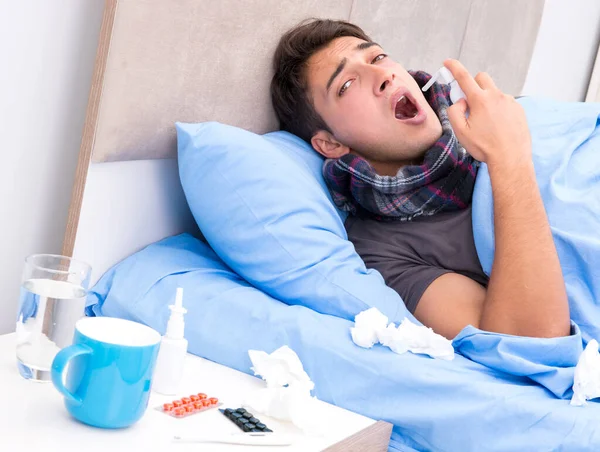 Homem doente com gripe deitado na cama — Fotografia de Stock