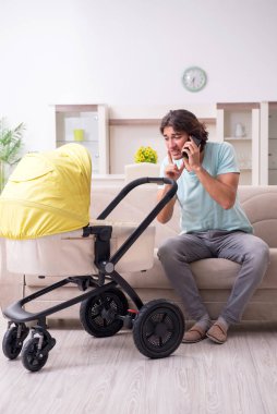 Bebek arabasında bebeğe bakan genç adam.