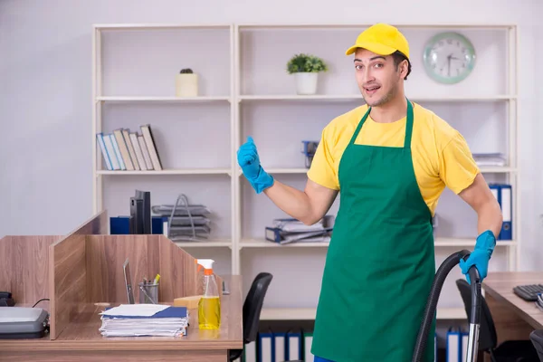 Junge männliche Auftragnehmer putzen das Büro — Stockfoto